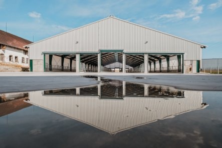 Pohled na exteriér stáje pro mladý skot od BUILDINGcentrum-HSV – zobrazení stavby pro mladý skot s ocelovým rámem a rolovacími v